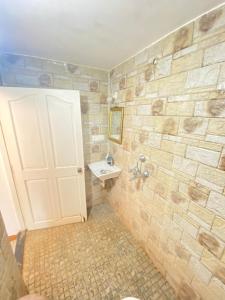 uma casa de banho com uma porta branca e um lavatório em sea shore guest house morjim beach em Morjim