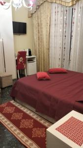 a bedroom with a bed with red sheets and a chair at La Casa di Sonia in Savona
