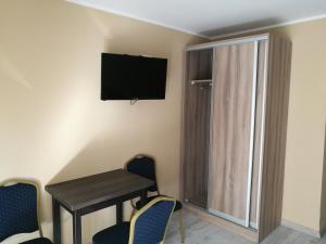 a room with a table and chairs and a television on the wall at Jarzębinowy Agroturystyka in Braniewo +40 photos
