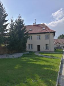 a large white house with a yard at Jarzębinowy Agroturystyka in Braniewo