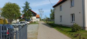 una casa y un coche estacionados junto a una valla en Jarzębinowy Agroturystyka, en Braniewo