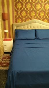 a blue bed with blue pillows in a bedroom at La Casa di Sonia in Savona