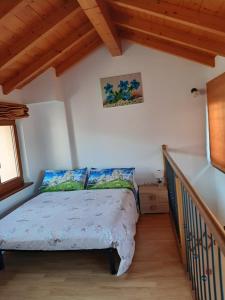 ein Schlafzimmer mit einem Bett in einem Zimmer mit Holzdecken in der Unterkunft Casa Rosetta in 