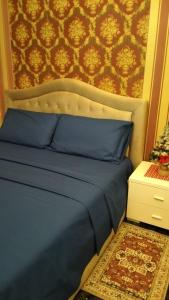 a bed with a blue bedspread and a wall at La Casa di Sonia in Savona