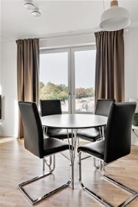 stół i krzesła w pokoju z oknem w obiekcie Stylish Urban Home in Stockholm w Sztokholmie