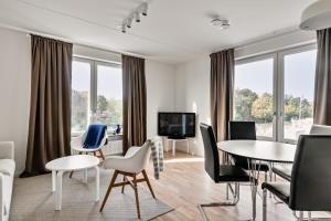 uma sala de estar com mesas e cadeiras e uma televisão em Stylish Urban Home in Stockholm em Estocolmo
