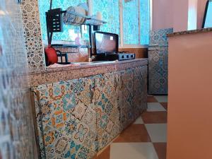 uma cozinha com um balcão com um lavatório e uma televisão em Surf Taliouin Appartment Taghazout em Taghazout