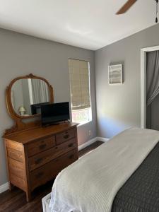 a bedroom with a bed and a dresser with a mirror at Eastside Costa Mesa house in Costa Mesa