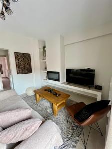 sala de estar con sofá, TV y mesa en Mountain Retreat I - Karpenisi, en Karpenisi