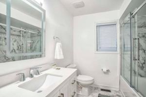a white bathroom with a sink and a toilet at Designer 4BR Executive Townhome w/Parking in Mississauga +15 photos