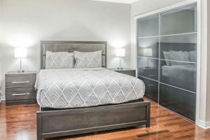 una camera da letto con un grande letto con due comodini di Designer 4BR Executive Townhome w/Parking a Mississauga