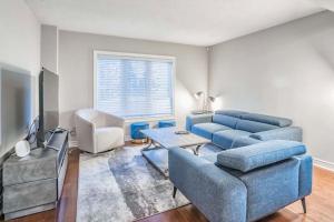 a living room with a blue couch and a tv at Designer 4BR Executive Townhome w/Parking in Mississauga