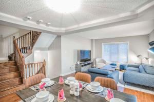 Designer 4BR Executive Townhome w/Parking في ميسيساوغا: غرفة معيشة مع أريكة زرقاء وطاولة