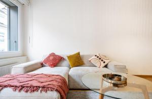 uma sala de estar com um sofá e uma mesa de vidro em Stylish Lakeside Home by the Jet d'Eau em Genebra