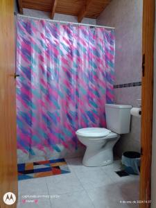 baño con aseo y cortina de ducha rosa en Casa en Nueva Atlantis en Mar de Ajó