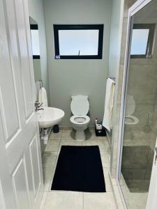 a bathroom with a toilet and a sink and a shower at Ice Holiday Home in Kiddʼs Beach