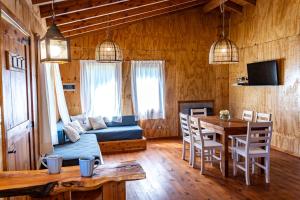 a living room with a table and a bed and a dining room at Wild Cabañas Boutique in Lago Puelo