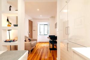 eine Küche und ein Wohnzimmer mit weißen Wänden und Holzböden in der Unterkunft Martin Vaz Home Design in Lissabon