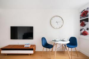 een woonkamer met 2 stoelen en een tafel en een klok bij Spectacular Studio in Manhattan in New York