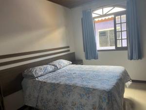 um quarto com uma cama e uma janela em Casa confortável e espaçosa . em Florianópolis
