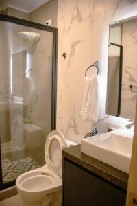 a bathroom with a toilet and a sink and a shower at Hotel Amazonas Suite , habitación sencilla in Nueva Loja