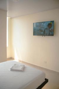 sypialnia z łóżkiem z telewizorem na ścianie w obiekcie Hotel Amazonas Suite , habitación sencilla w Nueva Loja