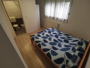 a bedroom with a bed with a blue and white comforter at Apartment Mejdan in Tuzla