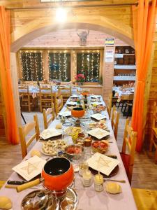 サン・ニコラにあるAppartamenti Le Bistrotの長テーブルと食べ物を用意したダイニングルーム