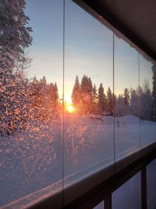 a window with a view of the sunset in the snow at Levinlaita in Levi
