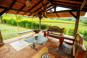 a patio with benches and a table and a swing at Finca Nuevo Monarca in Pereira