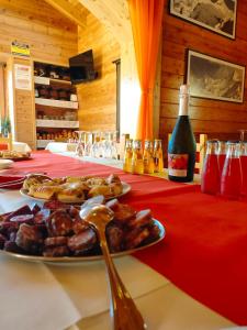 uma mesa com uma garrafa de vinho e um prato de comida em Appartamenti Le Bistrot em Saint Nicolas