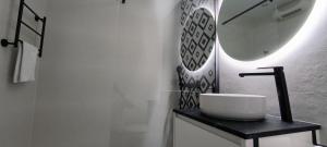 a white bathroom with a sink and a mirror at Denia Beach Apartament Jardín privado y piscina in El Verger