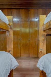 two beds in a room with wooden cabinets at Hostel Casa Roble in Mendoza