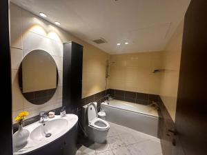 La salle de bains est pourvue d'un lavabo, de toilettes et d'une baignoire. dans l'établissement Spacious 3 bedroom apartment, à Khobar
