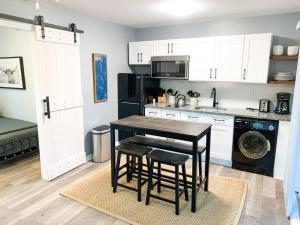 a kitchen with white cabinets and a table and stools at Tiny house- near Duke Univ/Hospital, walk to food in Durham