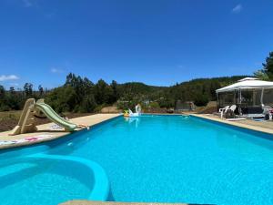a large blue swimming pool with a slide and a slidesktop at Hotel Casa Las Taguas in Constitución