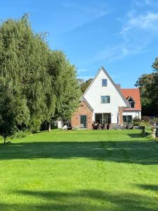 a large white house with a tree in the yard at Silvercopse House in Kingston Bagpuze