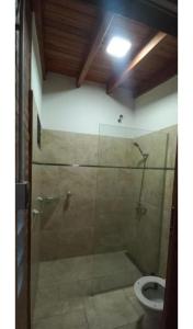 a bathroom with a glass shower with a toilet at La Cabañita in Colonia Caroya