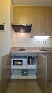 eine Küche mit einer Theke und einer Mikrowelle in der Unterkunft The Glen Haven - Twin Lakes Tagaytay in Tagaytay