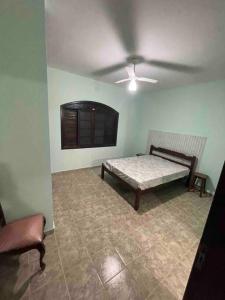 a room with a bed and a ceiling fan at Maravilhosa Casa a 20 Metros da PRAIA in Caraguatatuba