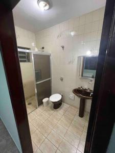 a bathroom with a shower and a toilet and a sink at Maravilhosa Casa a 20 Metros da PRAIA in Caraguatatuba