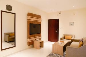 uma sala de estar com televisão e duas cadeiras em HELVIN em Abha