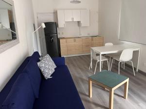 a living room with a blue couch and a kitchen at EMY HOUSE in La Laguna