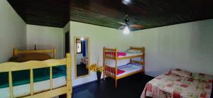 a bedroom with two bunk beds and a ceiling fan at Hostel e Pousada Araquari in Paraty
