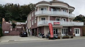 un grand bâtiment rose avec un panneau devant lui dans l'établissement Apartmani Tika, à Golubac