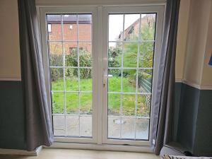 a sliding glass door with a view of a yard at Home in Beckton. Docklands. London City Airport. in London