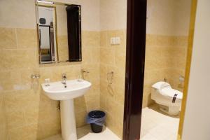 uma casa de banho com um lavatório e um WC em HELVIN em Abha