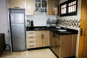 a kitchen with a stainless steel refrigerator and cabinets at Baya view surfside in Aourir