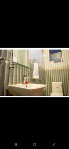 2 fotos de un baño con lavabo y aseo en Adriel homes and tours en Kigali