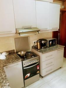 cocina pequeña con fogones y microondas en Adriel homes and tours en Kigali